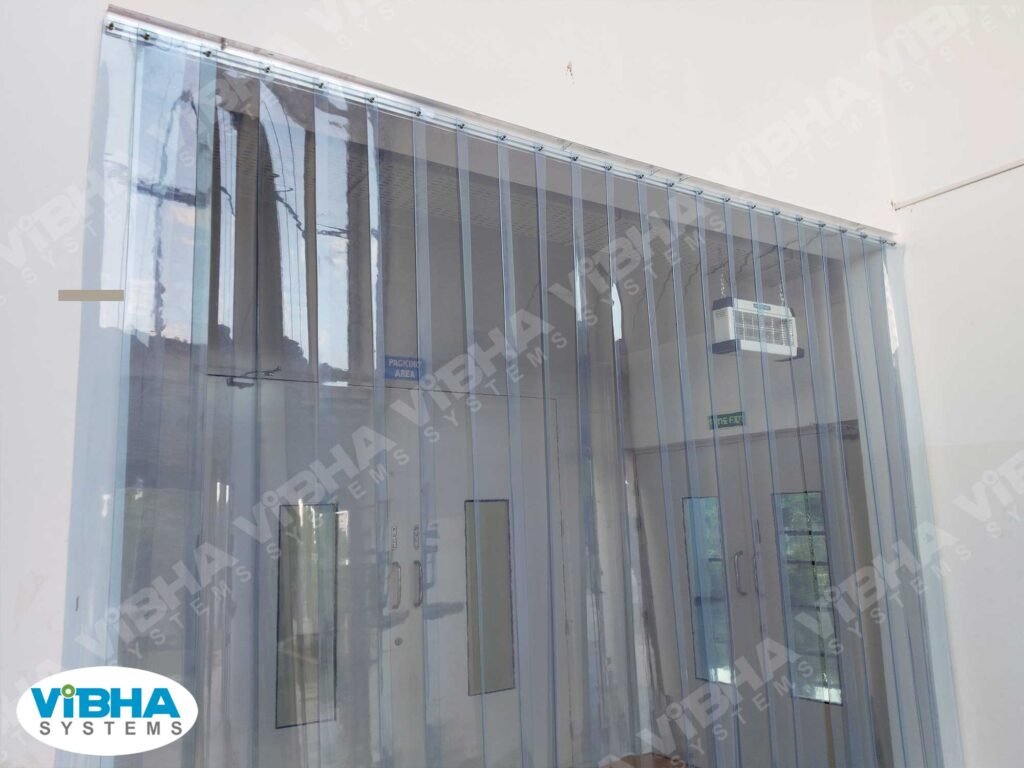 Clear PVC strip curtains on a shop floor door maintaining hygiene and workflow efficiency.