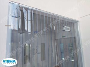 Clear PVC strip curtains on a shop floor door maintaining hygiene and workflow efficiency.