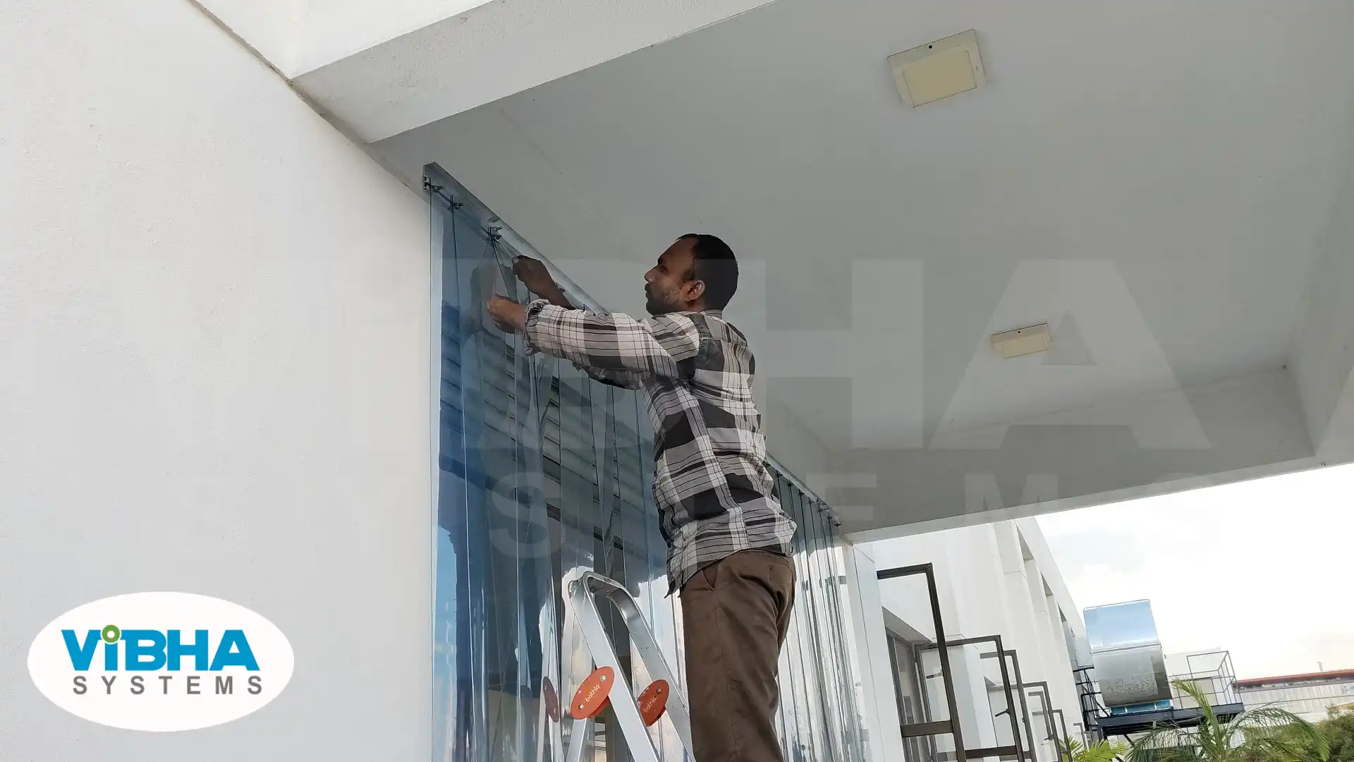 Technicians fixing PVC strip curtains at a busy warehouse dock in Chennai.